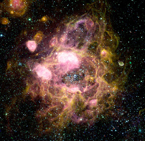 N11, una superburbuja de unos 300 años luz de tamaño situada en la Gran Nube de Magallanes, una galaxia cercana a la Vía Láctea. Las estrellas responsables de su creación son las que se aprecian en el centro de la burbuja y tienen una edad de unos 4 millones de años (la primera generación, de la cual varias estrellas masivas han explotado ya). Las zonas rosadas brillantes en los bordes de la superburbuja son regiones H II creadas por una segunda generación de estrellas masivas, unos 3 millones de años más jóvenes que las anteriores. La segunda generación es el resultado de la formación estelar originada por la compresión del material circundante por los vientos estelares y explosiones de supernova de la primera generación.